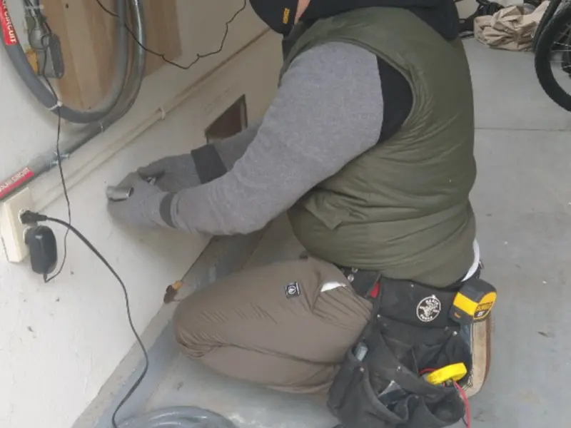 Electrician performing outlet wiring in a Tucson Estates garage